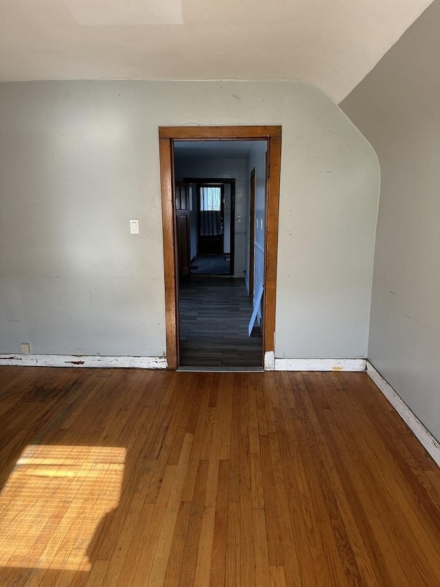 spare room featuring wood-type flooring and baseboards