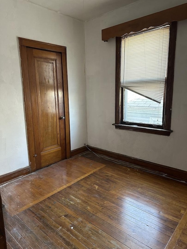spare room with hardwood / wood-style floors and baseboards