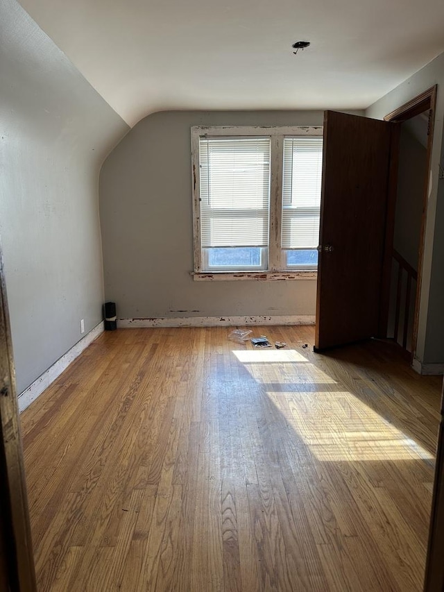 additional living space with wood finished floors and lofted ceiling