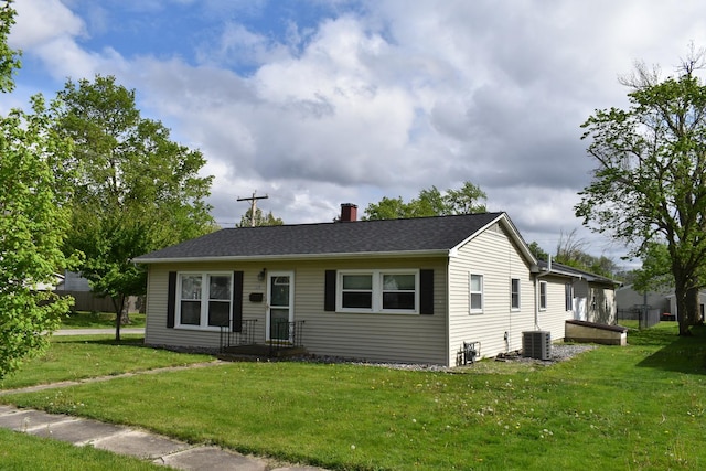 view of front facade featuring central AC unit, a front lawn, and a chimney