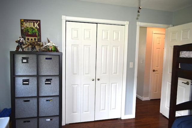 unfurnished bedroom with a closet, baseboards, and dark wood finished floors