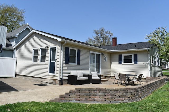 rear view of house featuring fence, entry steps, a patio, and a chimney