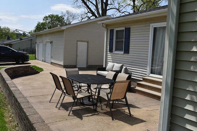 view of patio / terrace with outdoor dining area, entry steps, and a detached garage