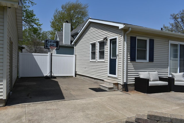 view of side of home with an outdoor hangout area, a patio, fence, and entry steps