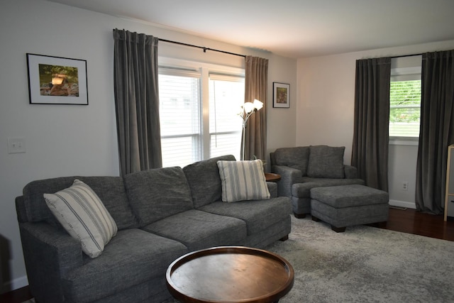 living area with dark wood-style flooring and baseboards
