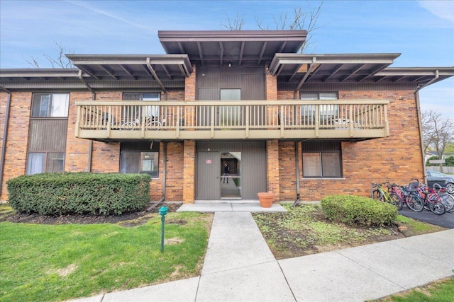 view of front of home with brick siding and a balcony