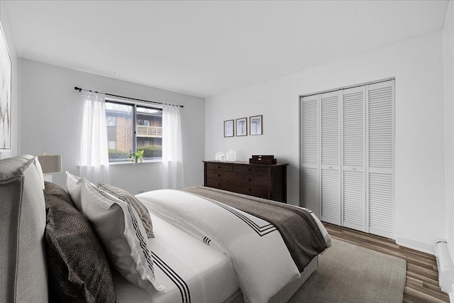 bedroom featuring baseboards, wood finished floors, and a closet