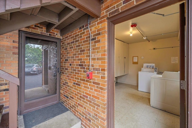 entrance to property with brick siding and washer and clothes dryer