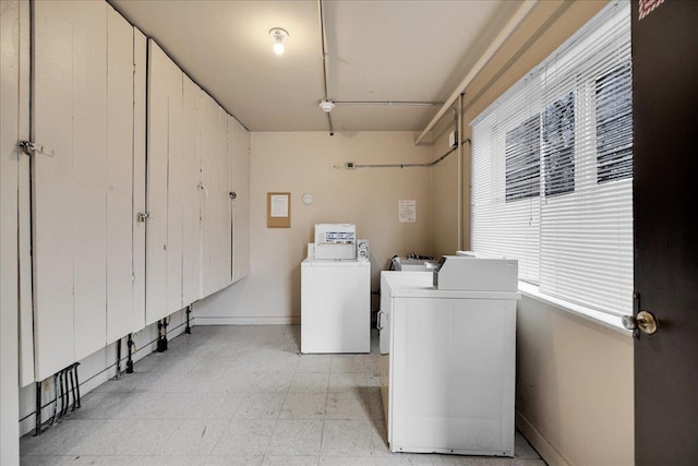 laundry area featuring baseboards, a sink, washing machine and clothes dryer, and light floors