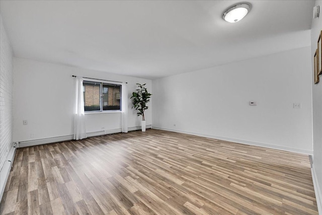 empty room with light wood-style flooring and baseboards