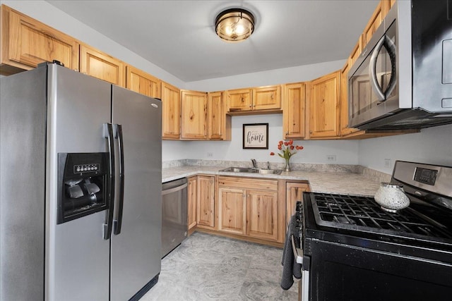 kitchen with light brown cabinets, stainless steel appliances, light countertops, and a sink