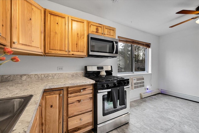 kitchen with stainless steel appliances, light countertops, a wall mounted AC, a sink, and a ceiling fan