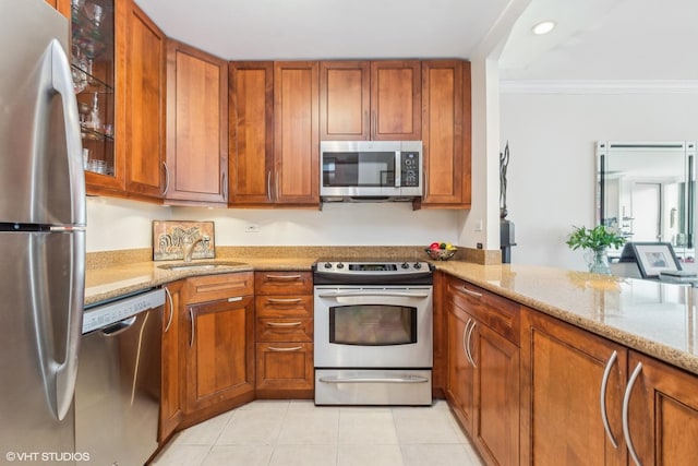 1555 N Sandburg Ter Unit 115K, Chicago, IL 60610 - kitchen with light stone counters, crown molding, a sink, stainless steel appliances, and brown cabinetry