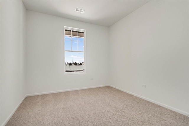 unfurnished room featuring baseboards, visible vents, and carpet
