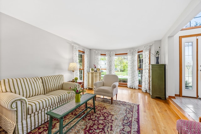 living area featuring healthy amount of natural light, light wood-style flooring, and baseboards