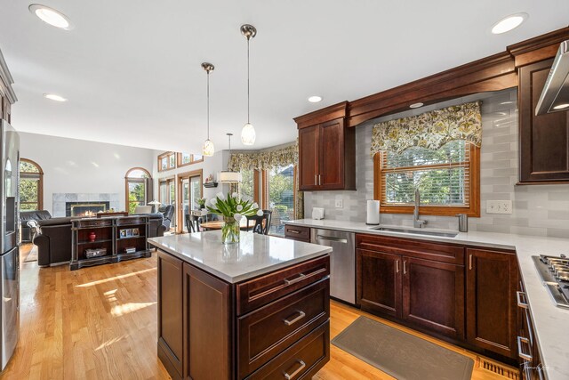 kitchen featuring stainless steel appliances, a sink, decorative backsplash, decorative light fixtures, and recessed lighting
