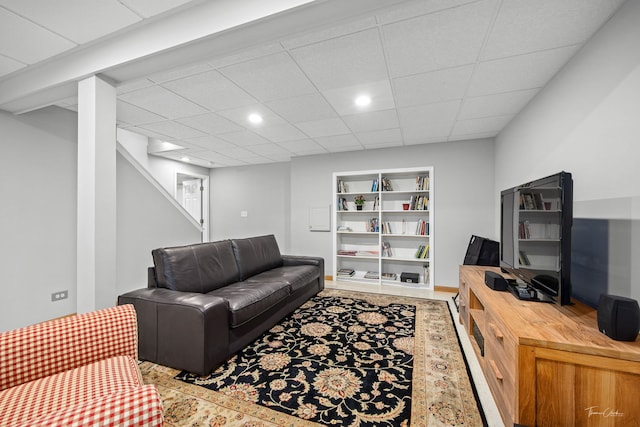 living room featuring recessed lighting, built in features, and a paneled ceiling