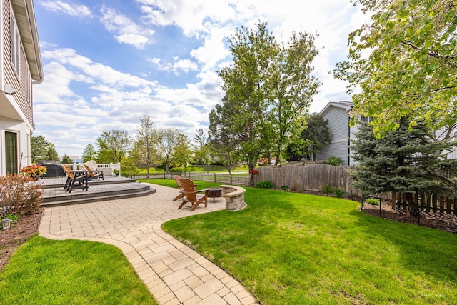 view of yard with an outdoor fire pit, a wooden deck, and a patio