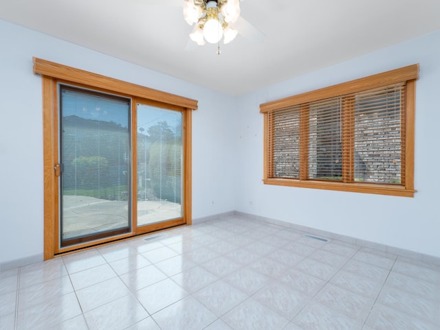 unfurnished room featuring baseboards, ceiling fan, and visible vents