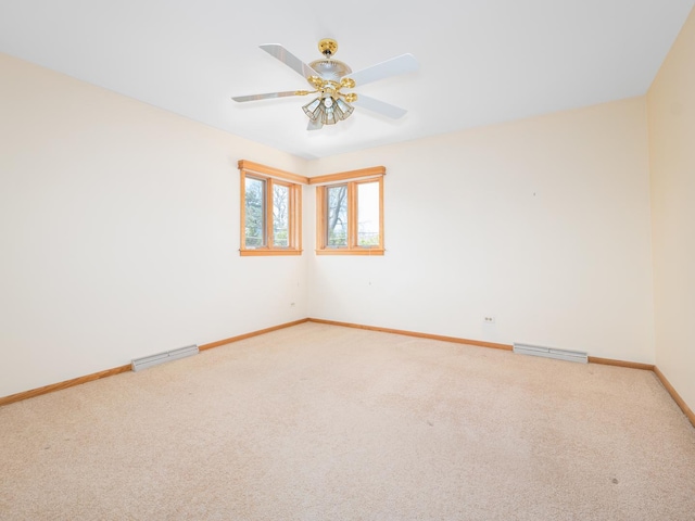 carpeted empty room featuring baseboards, a ceiling fan, and visible vents