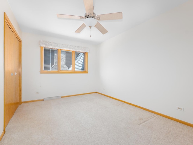 empty room featuring baseboards, visible vents, and light carpet