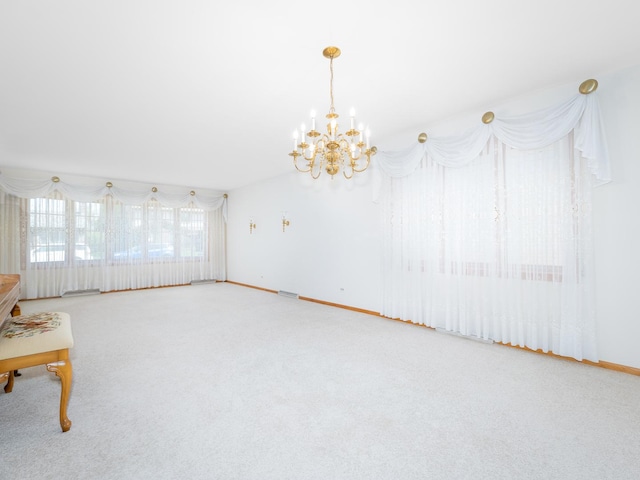 unfurnished room featuring baseboards, carpet flooring, and a notable chandelier