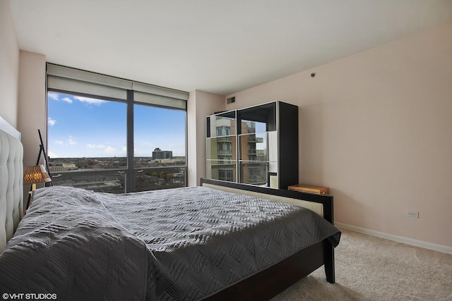 carpeted bedroom with baseboards and a wall of windows