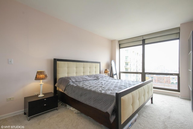 bedroom featuring carpet floors, baseboards, and expansive windows
