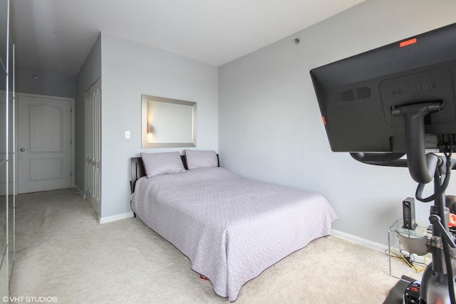 bedroom with light carpet, baseboards, and a closet
