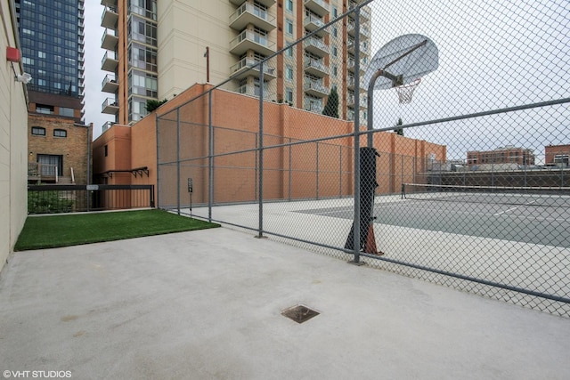 view of basketball court featuring fence and a tennis court