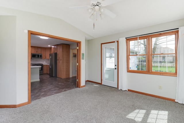 spare room featuring vaulted ceiling, baseboards, ceiling fan, and carpet flooring