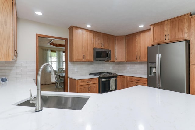 kitchen featuring recessed lighting, appliances with stainless steel finishes, a sink, and tasteful backsplash