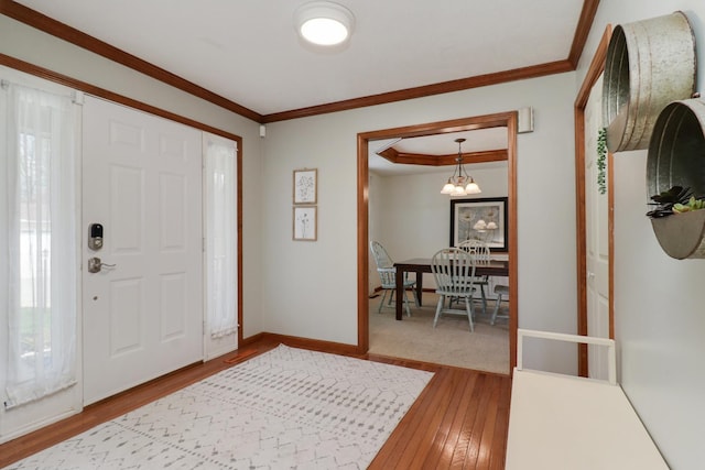 entryway with crown molding, baseboards, and hardwood / wood-style floors