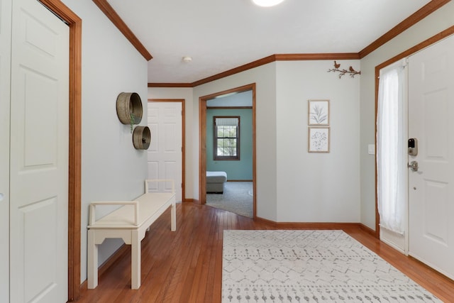 entrance foyer with crown molding, baseboards, and wood finished floors