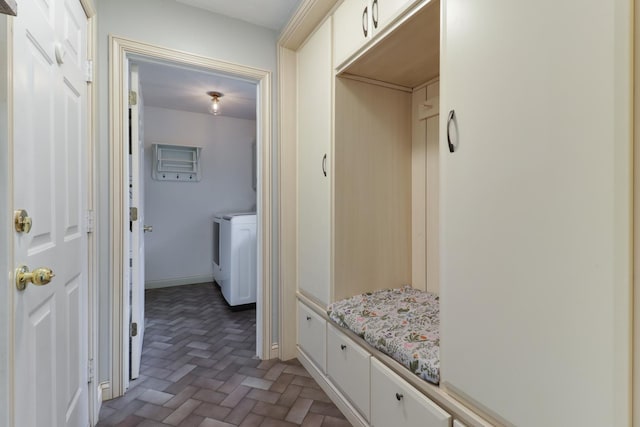 mudroom with baseboards, brick floor, and washing machine and clothes dryer