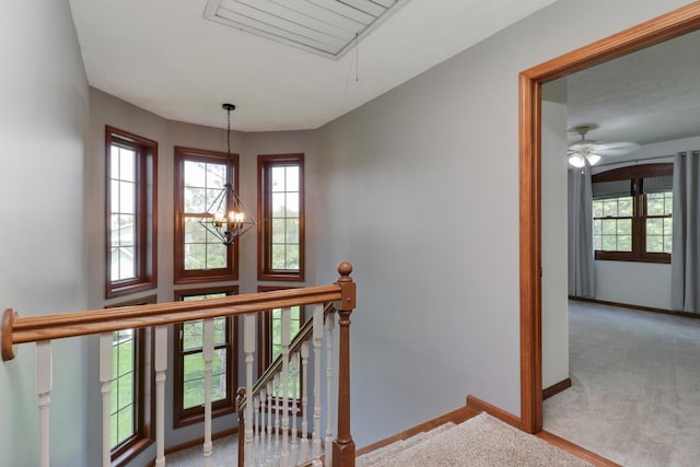 staircase featuring ceiling fan with notable chandelier, baseboards, plenty of natural light, and carpet flooring