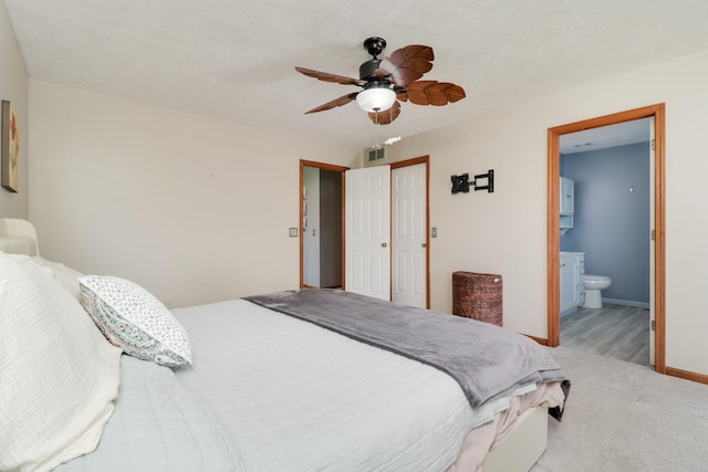 bedroom featuring ceiling fan, visible vents, baseboards, a closet, and connected bathroom