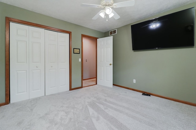 unfurnished bedroom featuring visible vents, carpet, baseboards, and a closet
