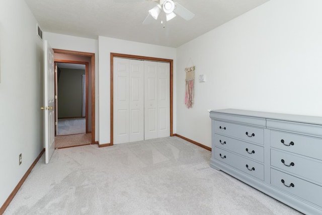 bedroom with light colored carpet, a ceiling fan, baseboards, visible vents, and a closet