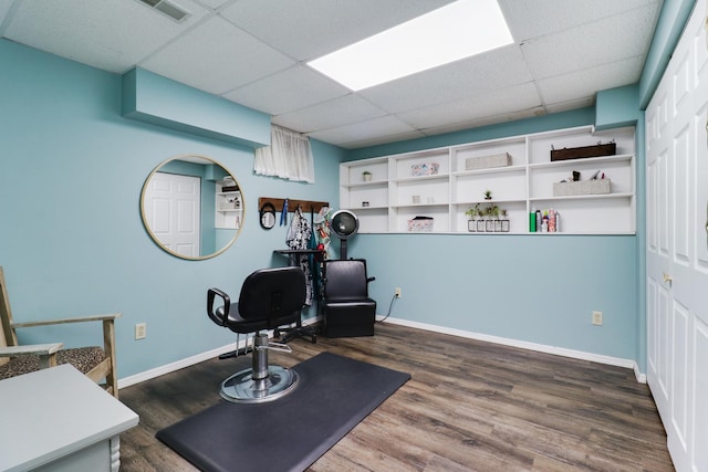 workout area with baseboards, visible vents, wood finished floors, and a paneled ceiling