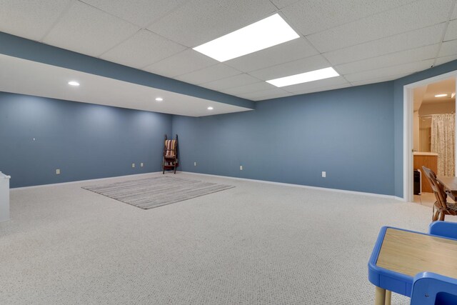 interior space featuring carpet floors, baseboards, and a drop ceiling