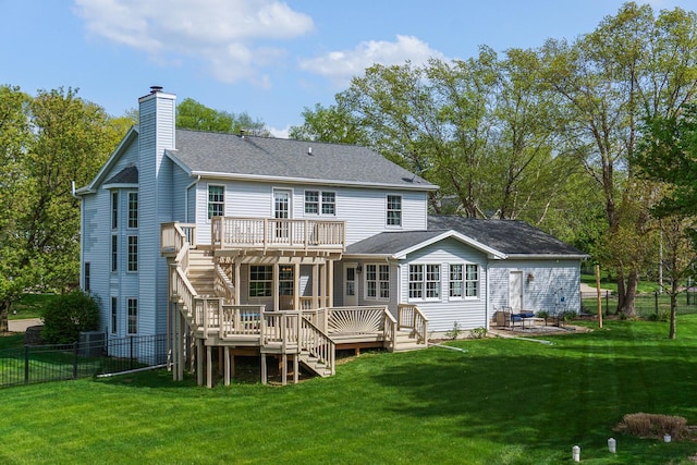 rear view of house with a chimney, a lawn, a deck, a fenced backyard, and stairs