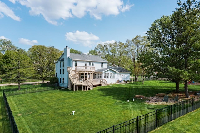 back of house with a fenced backyard, a wooden deck, a chimney, and a yard