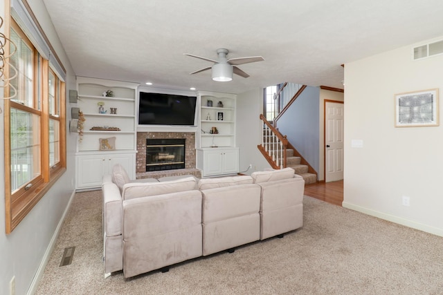 living room featuring carpet floors, stairs, a ceiling fan, baseboards, and visible vents