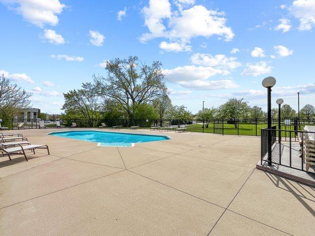 community pool with fence and a patio