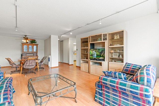 living room with a ceiling fan, track lighting, and light wood-type flooring