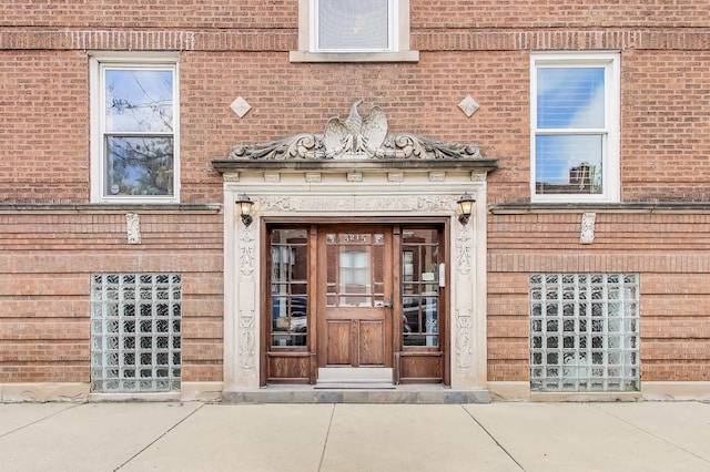 doorway to property featuring brick siding