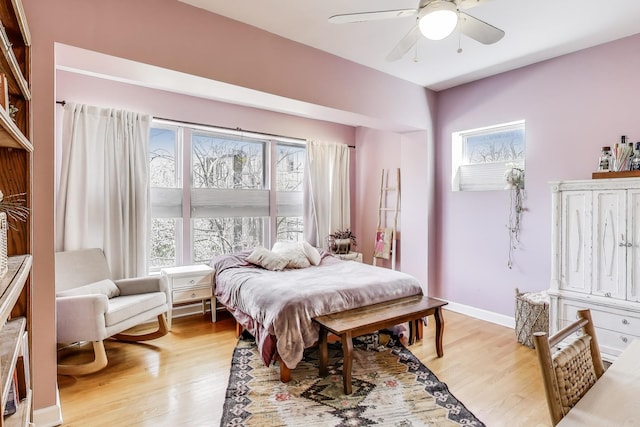 bedroom featuring baseboards, a ceiling fan, and light wood finished floors