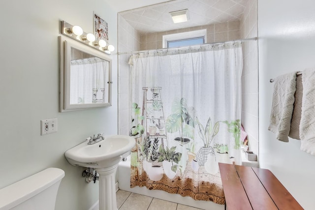 bathroom featuring tile patterned floors, toilet, and shower / tub combo with curtain