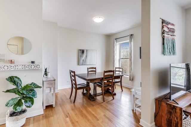 dining area featuring light wood-type flooring and baseboards